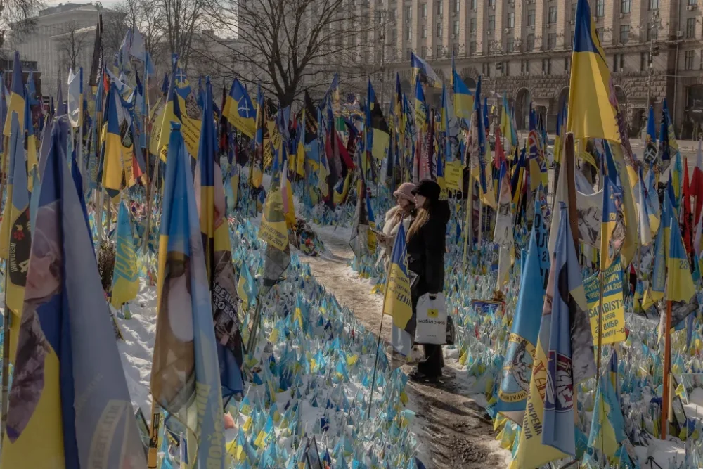 Відвідувачі стоять біля меморіалу, присвяченого українським та іноземним бійцям на Майдані Незалежності в Києві