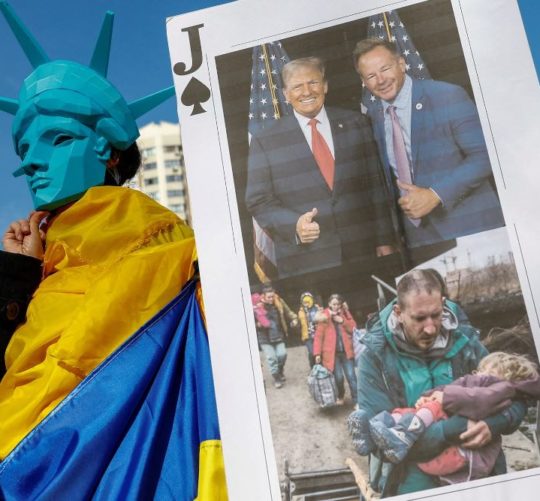 Учасник у масці із зображенням Статуї Свободи на мітингу проти позиції президента США Дональда Трампа щодо російсько-української війни на тлі нападу Росії на Україну перед посольством США в Києві, Україна, 8 березня 2025 року.