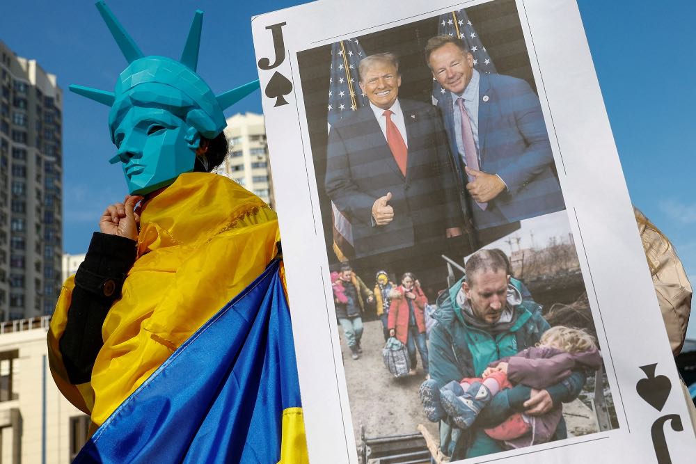 Учасник у масці із зображенням Статуї Свободи на мітингу проти позиції президента США Дональда Трампа щодо російсько-української війни на тлі нападу Росії на Україну перед посольством США в Києві, Україна, 8 березня 2025 року.