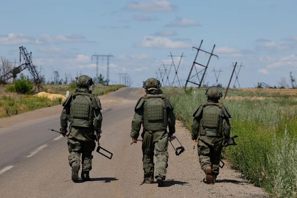 Cолдати шукають вибухівку під час операції з розмінування в червні в Донецькій області на сході України.