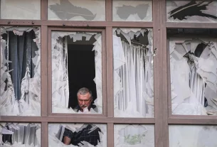 людина біля розбитих вікон післа атаки БЛПА на місто Київ