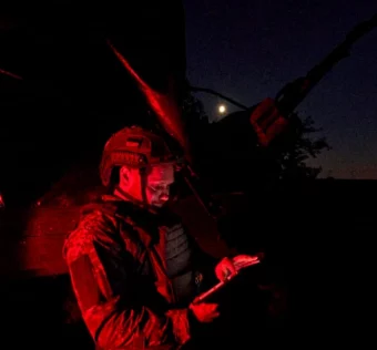 військовий у ночі з планшетом