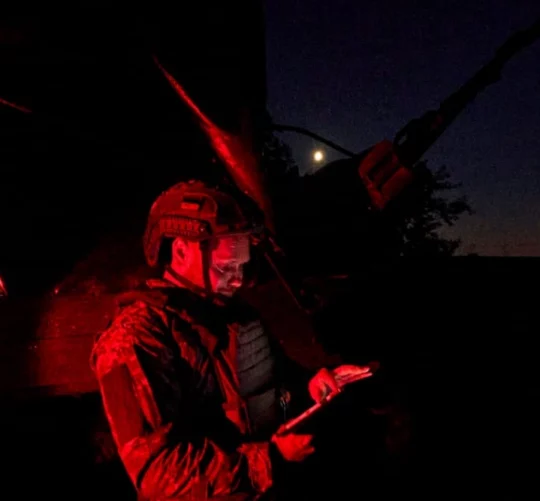 військовий у ночі з планшетом