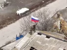 російські військові підіймають прапор у захопленому селі у Запорізькій області
