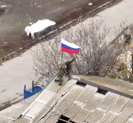 російські військові підіймають прапор у захопленому селі у Запорізькій області