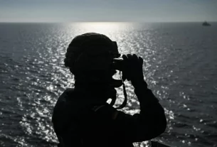 військовий дивиться у бінокль