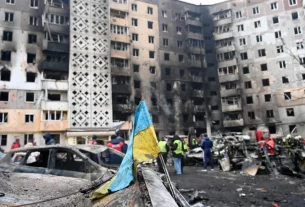 зруйнований житловий будинок дроном на фоні українського прапору