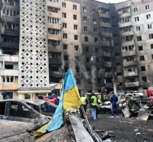 зруйнований житловий будинок дроном на фоні українського прапору