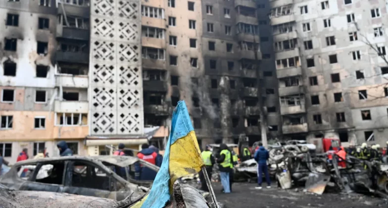 зруйнований житловий будинок дроном на фоні українського прапору