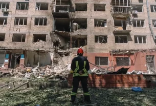 Рятувальник на місці російського авіаудару по житловому будинку в Києві в липні.