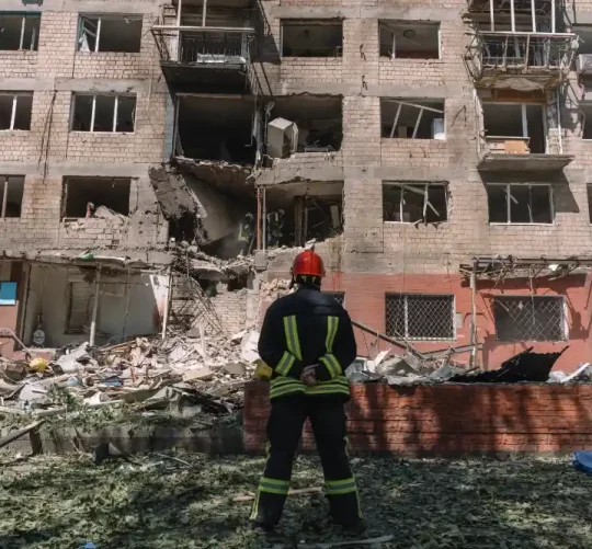 Рятувальник на місці російського авіаудару по житловому будинку в Києві в липні.