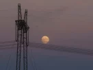 лінії високовольтних передач на фоні місяця