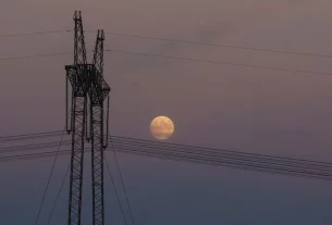 лінії високовольтних передач на фоні місяця