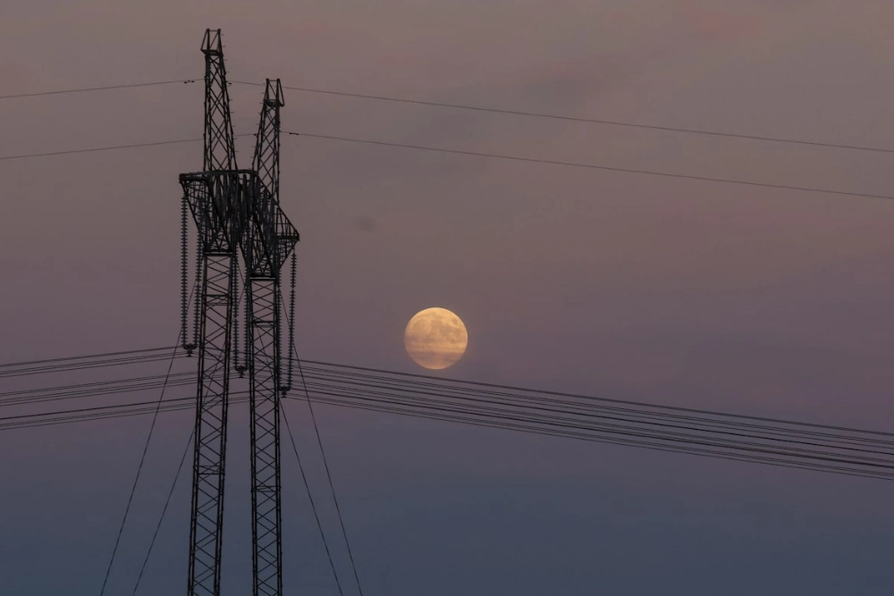 лінії високовольтних передач на фоні місяця