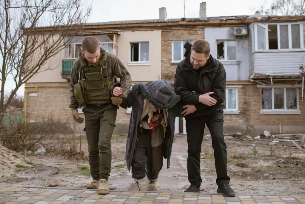 Жінка виходить зі свого дому в Гостомелі, одному з перших місць, що зазнало нападу під час вторгнення Росії