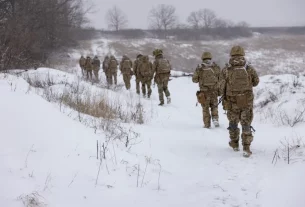 група військових йде по засніженому полю