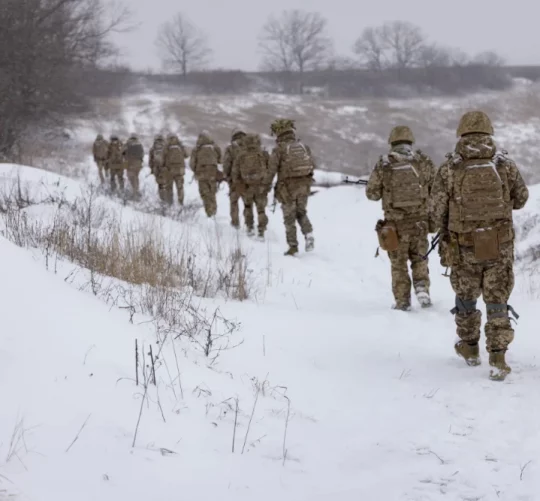 група військових йде по засніженому полю