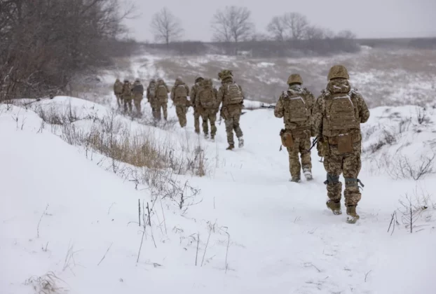 група військових йде по засніженому полю