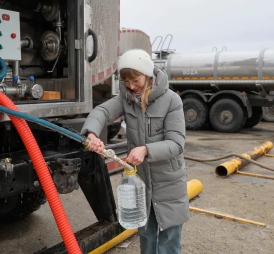 Жінка отримує питну воду, яку роздає влада в місті Донецьк у контрольованій Росією частині східної України, у четвер, 19 лютого 2026 року