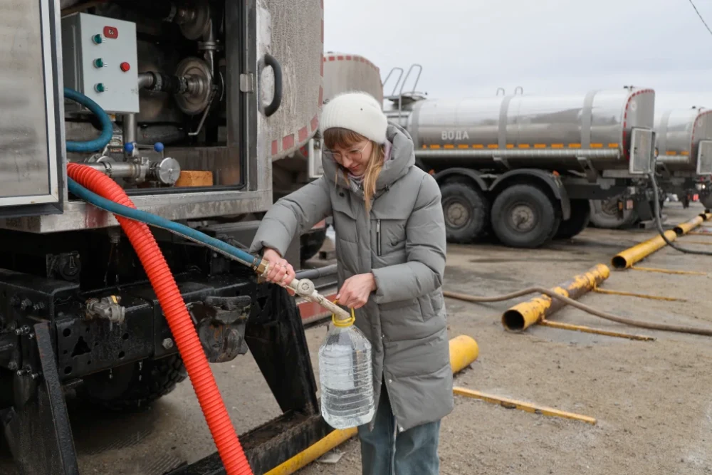 Жінка отримує питну воду, яку роздає влада в місті Донецьк у контрольованій Росією частині східної України, у четвер, 19 лютого 2026 року