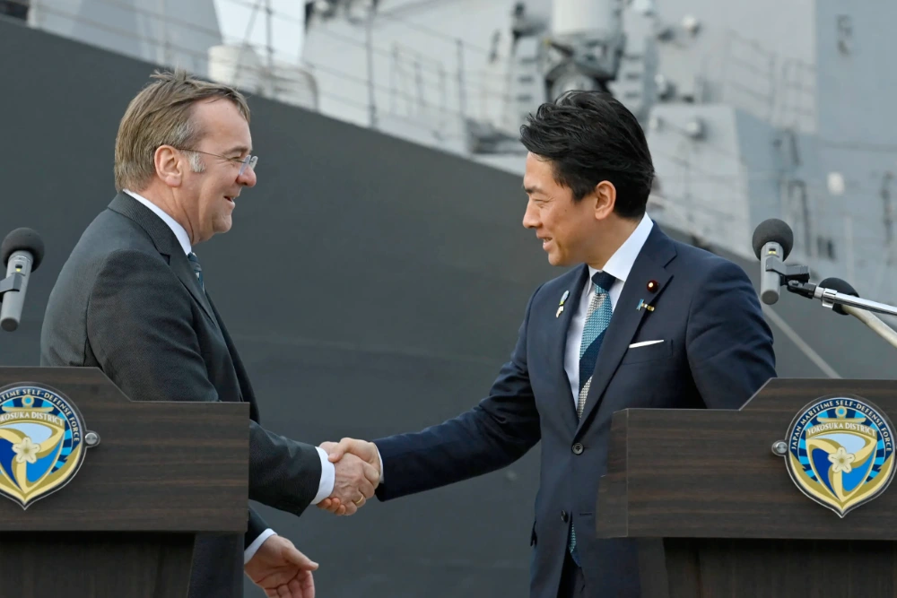 Міністр оборони Німеччини Борис Пісторіус і міністр оборони Японії Шіндзіро Коізумі потискають руки наприкінці спільного прес-релізу в Йокосуці, Японія, 22 березня 2026 року