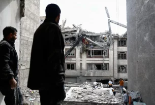 Чоловік дивиться на житлову будівлю, пошкоджену ударом США та Ізраїлю з Іраном, у Тегерані, Іран, 27 березня 2026 року