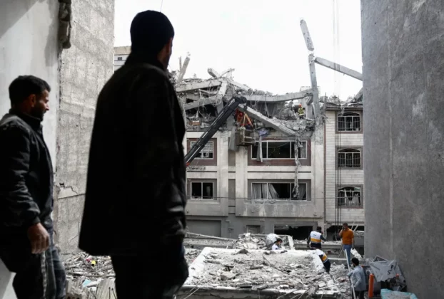 Чоловік дивиться на житлову будівлю, пошкоджену ударом США та Ізраїлю з Іраном, у Тегерані, Іран, 27 березня 2026 року