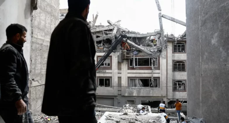 Чоловік дивиться на житлову будівлю, пошкоджену ударом США та Ізраїлю з Іраном, у Тегерані, Іран, 27 березня 2026 року