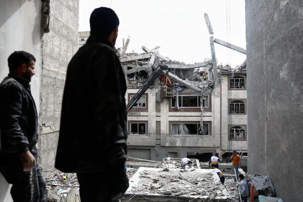 Чоловік дивиться на житлову будівлю, пошкоджену ударом США та Ізраїлю з Іраном, у Тегерані, Іран, 27 березня 2026 року