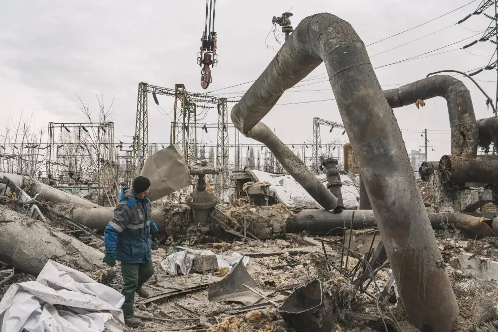 Працівники розчищають пошкоджені трубопроводи на Дарницькій ТЕЦ після російських авіаударів по Києву 4 лютого