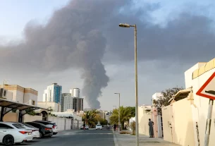 Люди спостерігають з вулиці, як високий стовп диму піднімається після вибуху в промисловій зоні Фуджейри в ОАЕ, 3 березня 2026 року