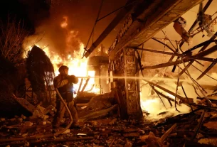 16-го числа пожежник проводить гасіння пожежі в житловому будинку, де спалахнула пожежа внаслідок удару російського безпілотника в Запоріжжі