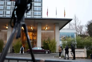 Люди стоять біля готелю InterContinental під час мирних переговорів між Росією та Україною за посередництва США в Женеві, Швейцарія, 18 лютого 2026 року