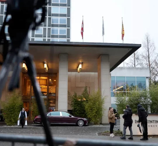 Люди стоять біля готелю InterContinental під час мирних переговорів між Росією та Україною за посередництва США в Женеві, Швейцарія, 18 лютого 2026 року