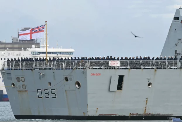 Члени екіпажу стоять на палубі HMS Dragon, який керується буксирами з військово-морської бази Портсмут на південному узбережжі Англії, 10 березня 2026 року