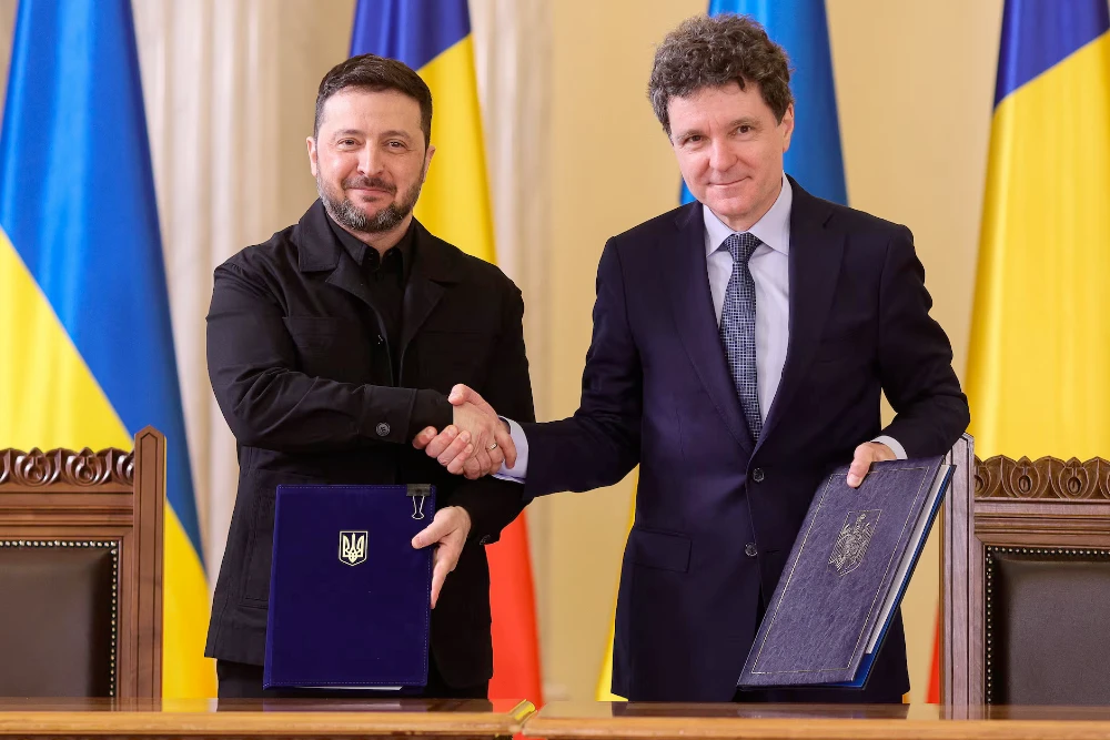 Президент Румунії Нікусор Дан і президент України Володимир Зеленський тиснуть один одному руки в Бухаресті, Румунія, 12 березня 2026 року.