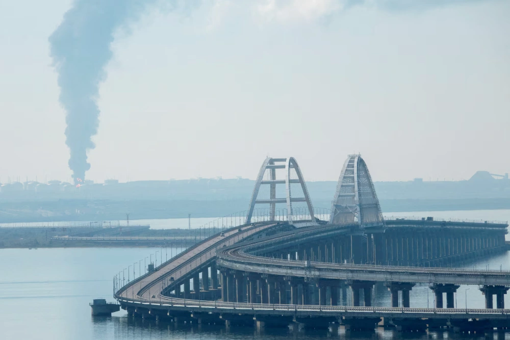 Дим піднімається з палаючого російського паливного складу біля Кримського мосту — ключового маршруту, що з'єднує Росію з Кримом, який Москва використовує для транспортування військ і техніки на фронт в Україні