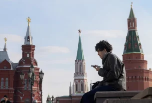 Чоловік перевіряє свій мобільний телефон у центрі Москви, Червона площа