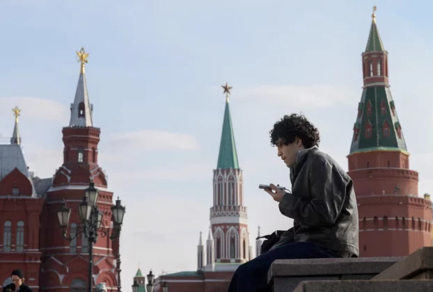 Чоловік перевіряє свій мобільний телефон у центрі Москви, Червона площа