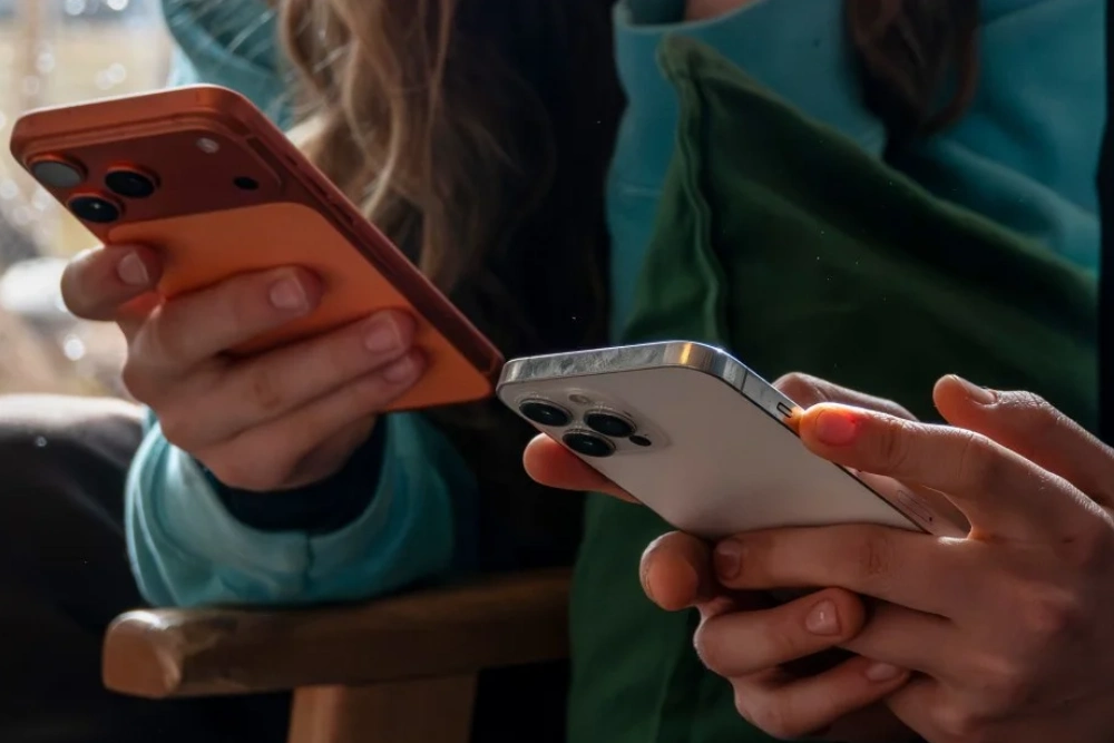 Молодь тримає мобільні телефони у руці