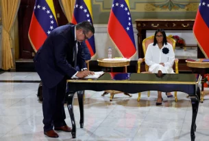 имчасовий президент Венесуели Делсі Родрігес спостерігає, як керівник компанії «Шеврон» підписує нафтову угоду