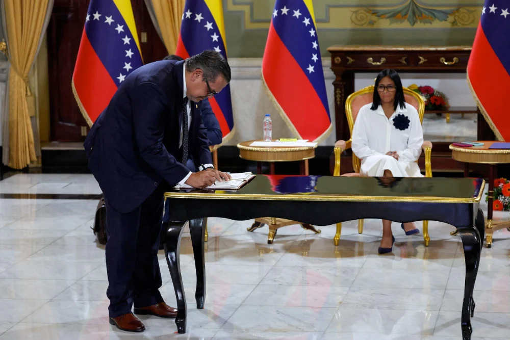 имчасовий президент Венесуели Делсі Родрігес спостерігає, як керівник компанії «Шеврон» підписує нафтову угоду