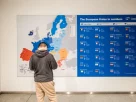 Відвідувач перед картою Європи та списком країн-членів Європейського Союзу в Європейському парламенті в Брюсселі 25 березня 2026 року