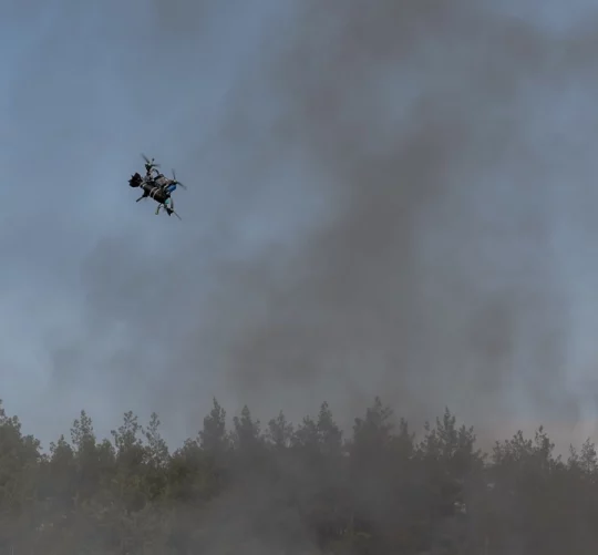 український безпілотний дальньої дії летить у задимленому небі