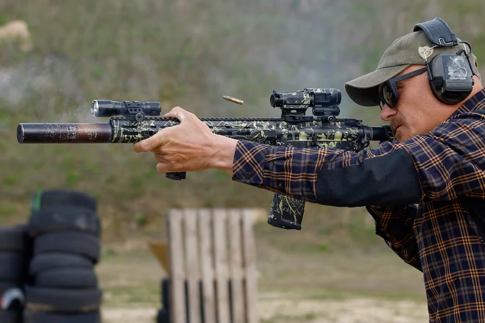 людина зі гвинтівкою робить постріл на тренуванні