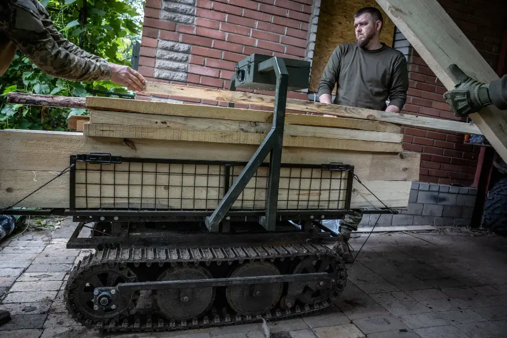 Минулого року на передовій базі в Костянтинівці українські військові завантажували безпілотний наземний транспортний засіб деревиною для піхотних підрозділів, які будували бункер на лінії фронту.