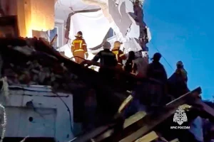 Співробітники МНС Росії працюють біля пошкодженого багатоповерхового житлового будинку, в який вдарив український безпілотник у Сизрані Самарської області Росії у середу, 22 квітня 2026 року