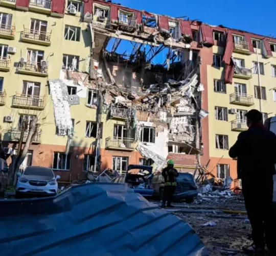 Рятувальник йде перед житловим будинком, який був сильно пошкоджений після російського удару в Одесі, Україна, 6 квітня 2026 року