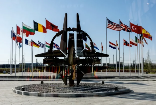 У штаб-квартирі в Брюсселі видно емблему НАТО на фоні прапорів 32 країн-членів