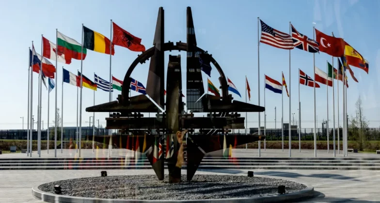 У штаб-квартирі в Брюсселі видно емблему НАТО на фоні прапорів 32 країн-членів